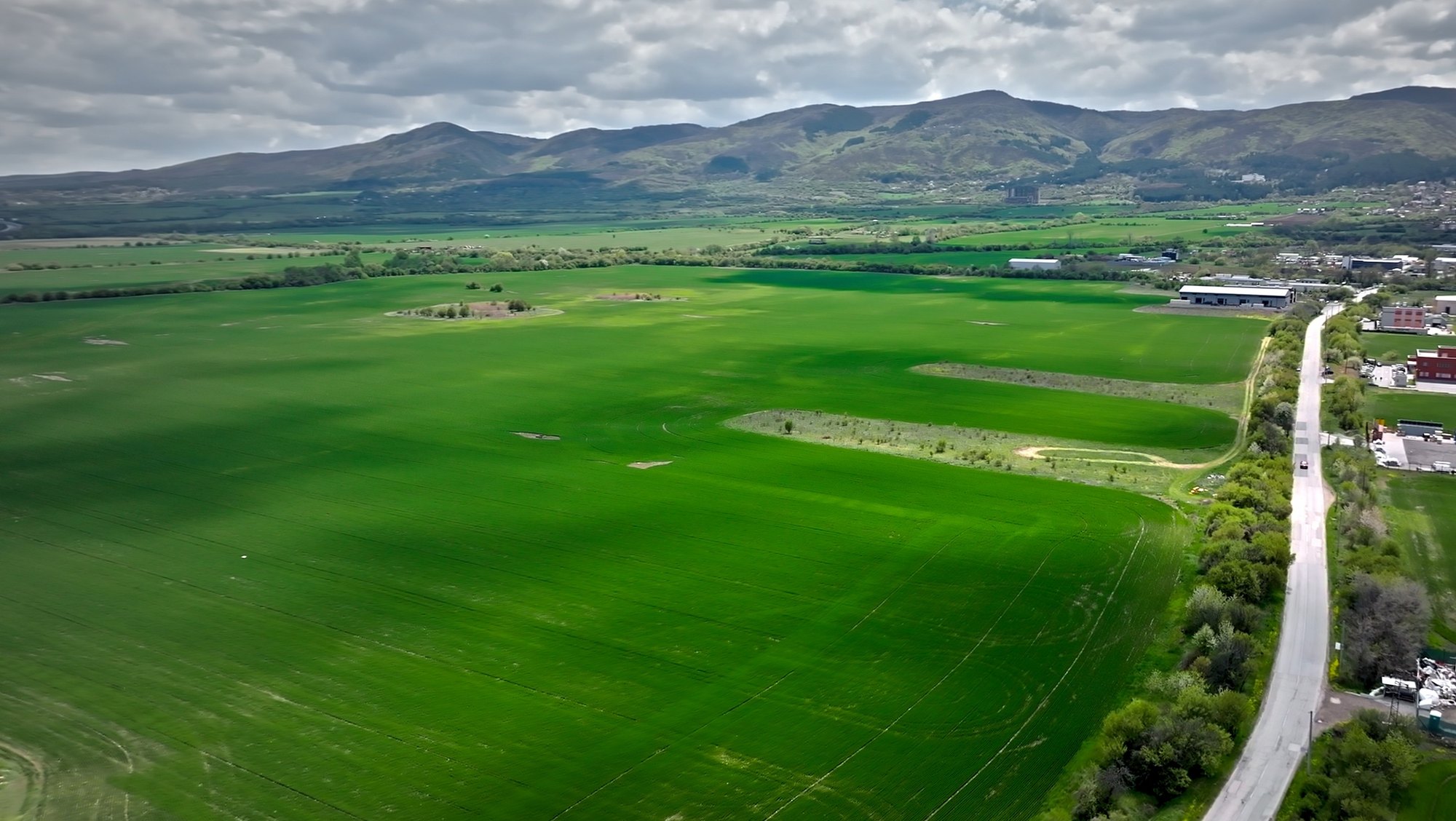 Dolni Lozen — the open fields of the site with the mountains behind