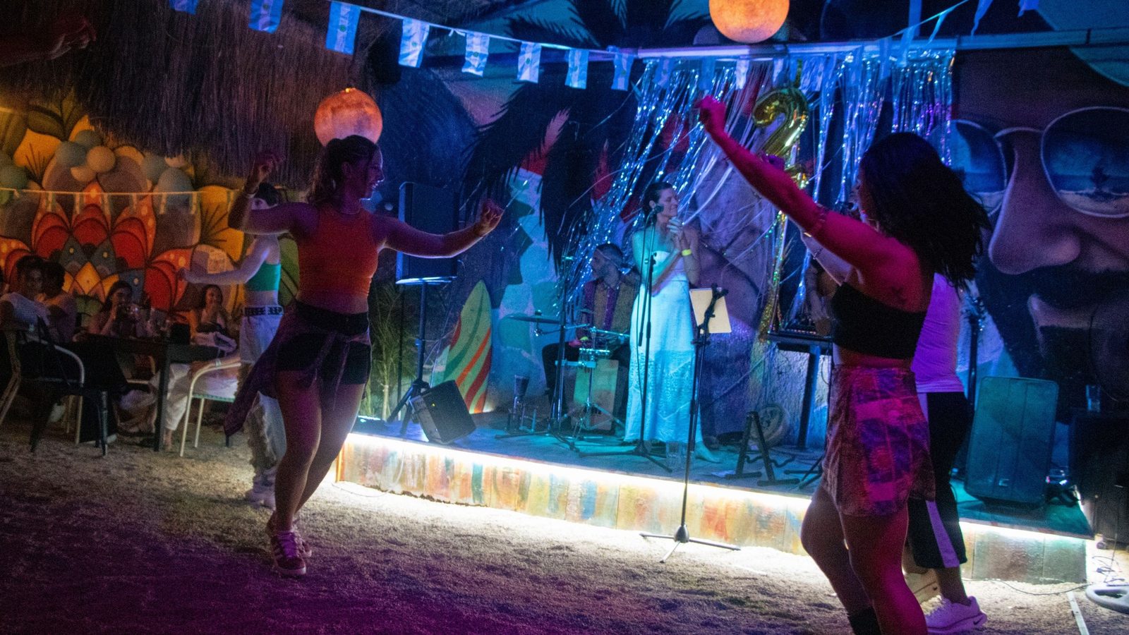 Gente bailando con la música en vivo frente al escenario de Zitla Playa, Playa del Carmen