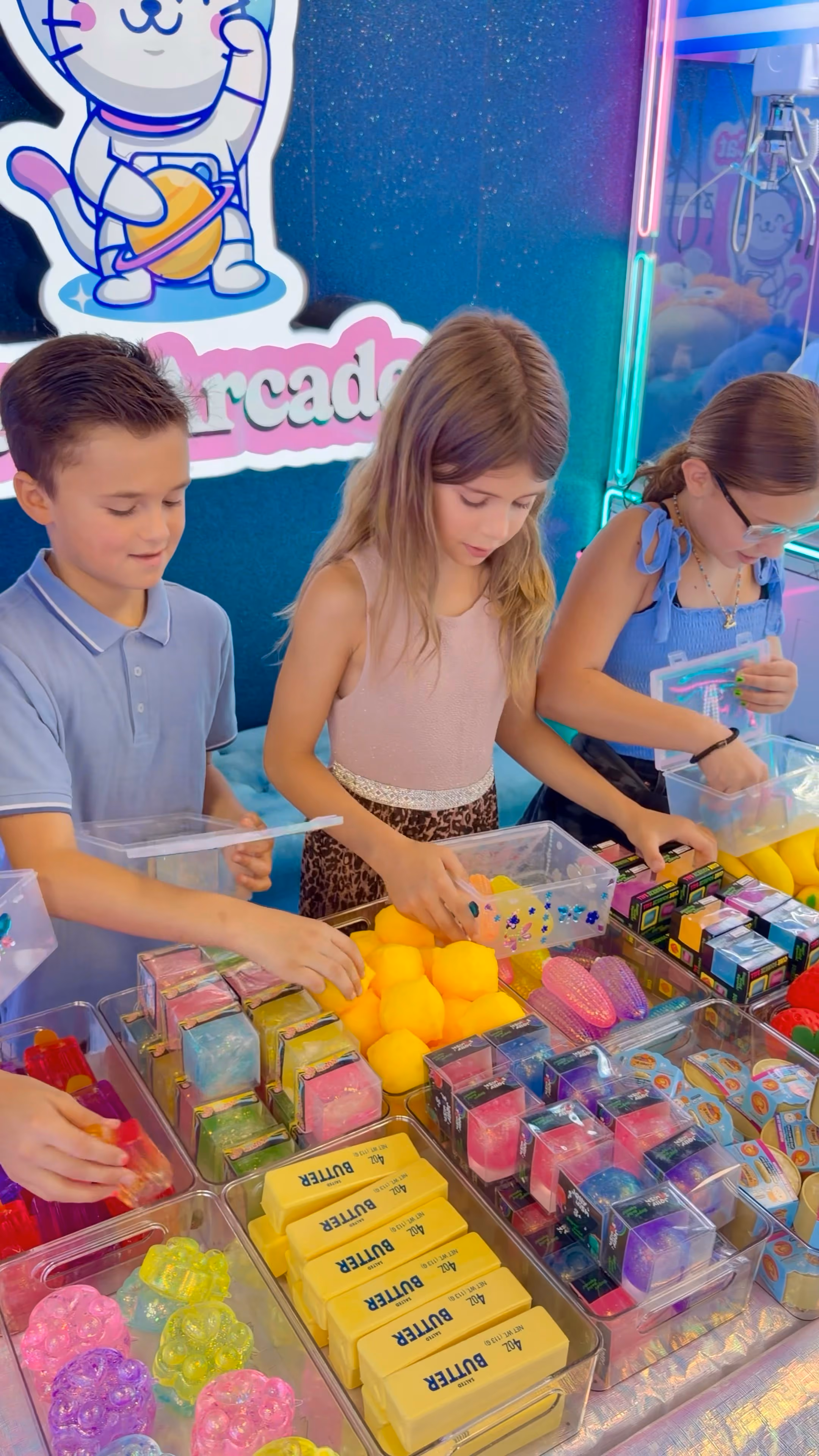 Three children choosing squishies from the trays at the Squishy Bar