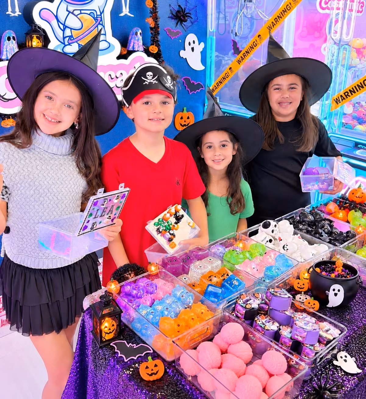 Kids in Halloween costumes holding their decorated keepsake boxes at the Squishy Bar