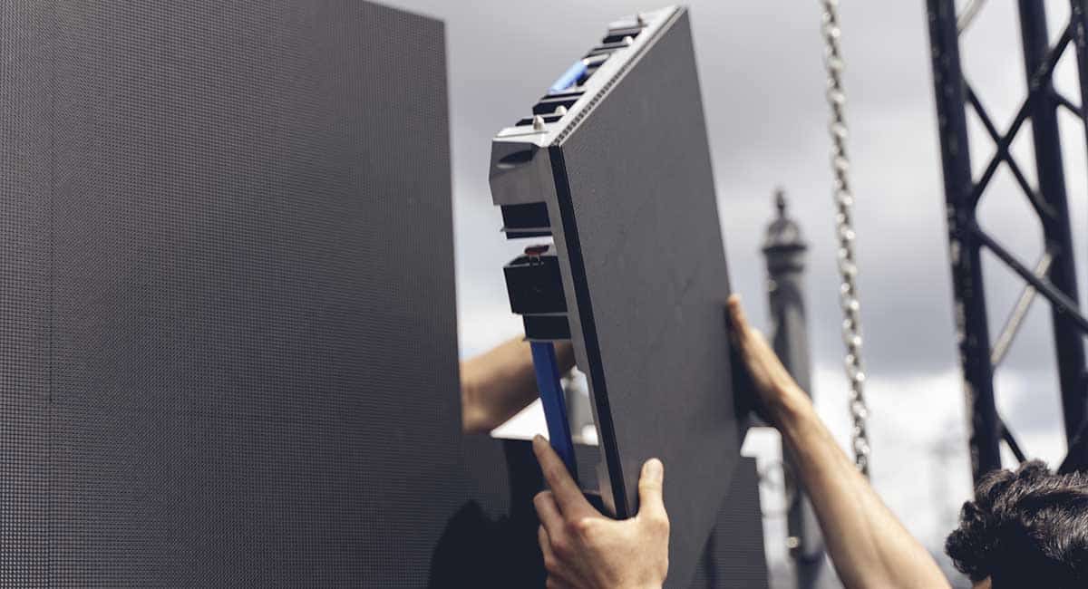 close up of two people linking outdoor led video wall panels together to form a large display
