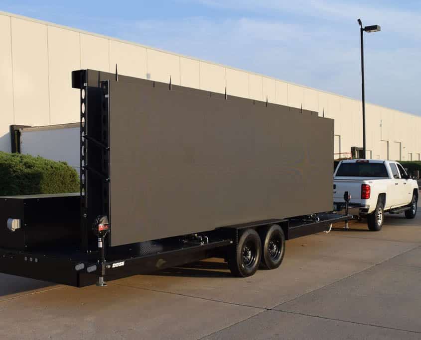 A large black trailer with a large screen on the back.