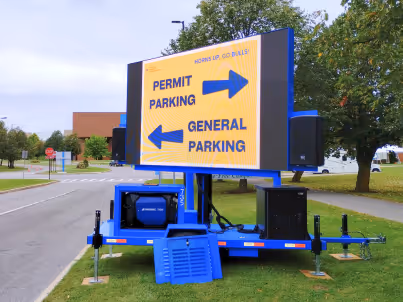 Outdoor sign directing permit parking right and general parking left on a trailer with blue frame.