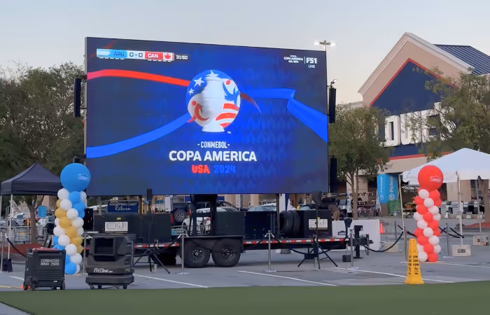 Large outdoor screen shows 0-0 score for Argentina vs Canada in Copa America USA 2024 event.