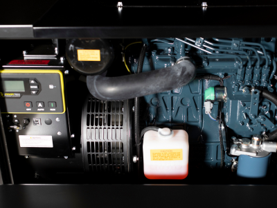 Close-up of engine components including hoses, a white fluid reservoir, and a control panel with buttons.