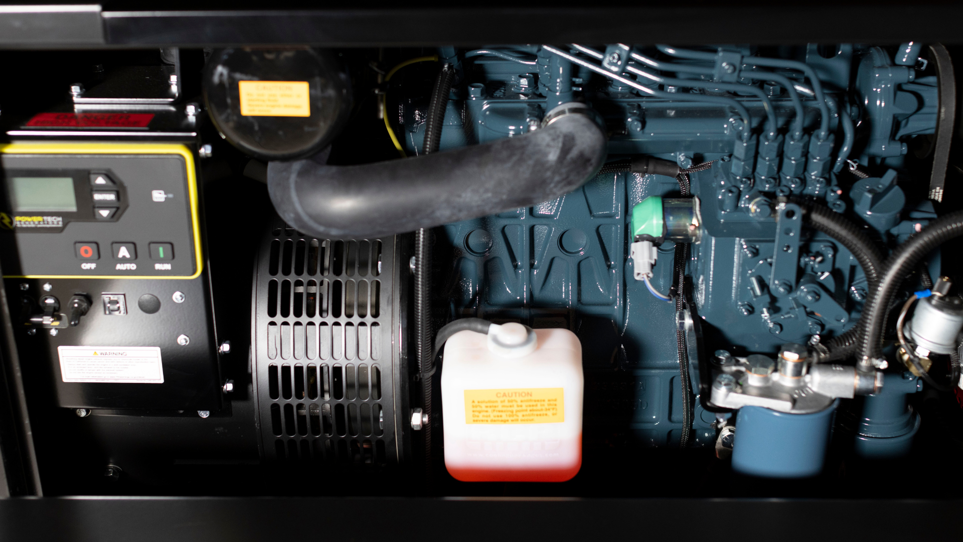 Close-up of generator engine components including a control panel and coolant reservoir.