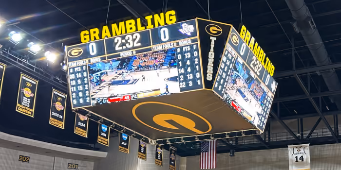 Grambling Tigers scoreboard showing 0-0 with 2:32 left in basketball game in gymnasium.