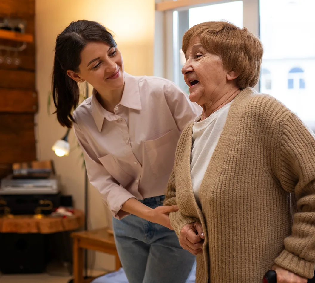 Caregiver supporting an elderly woman at home