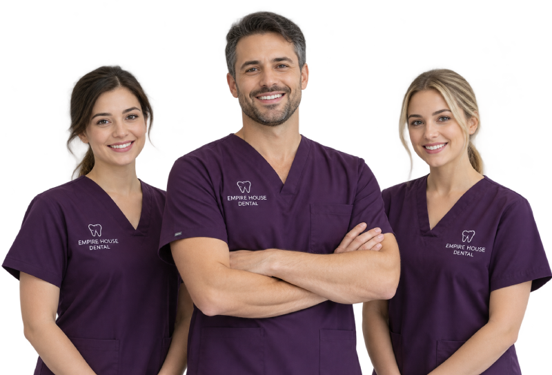 Three dental professionals wearing matching purple scrubs with Empire House Dental logos, smiling and standing close together.