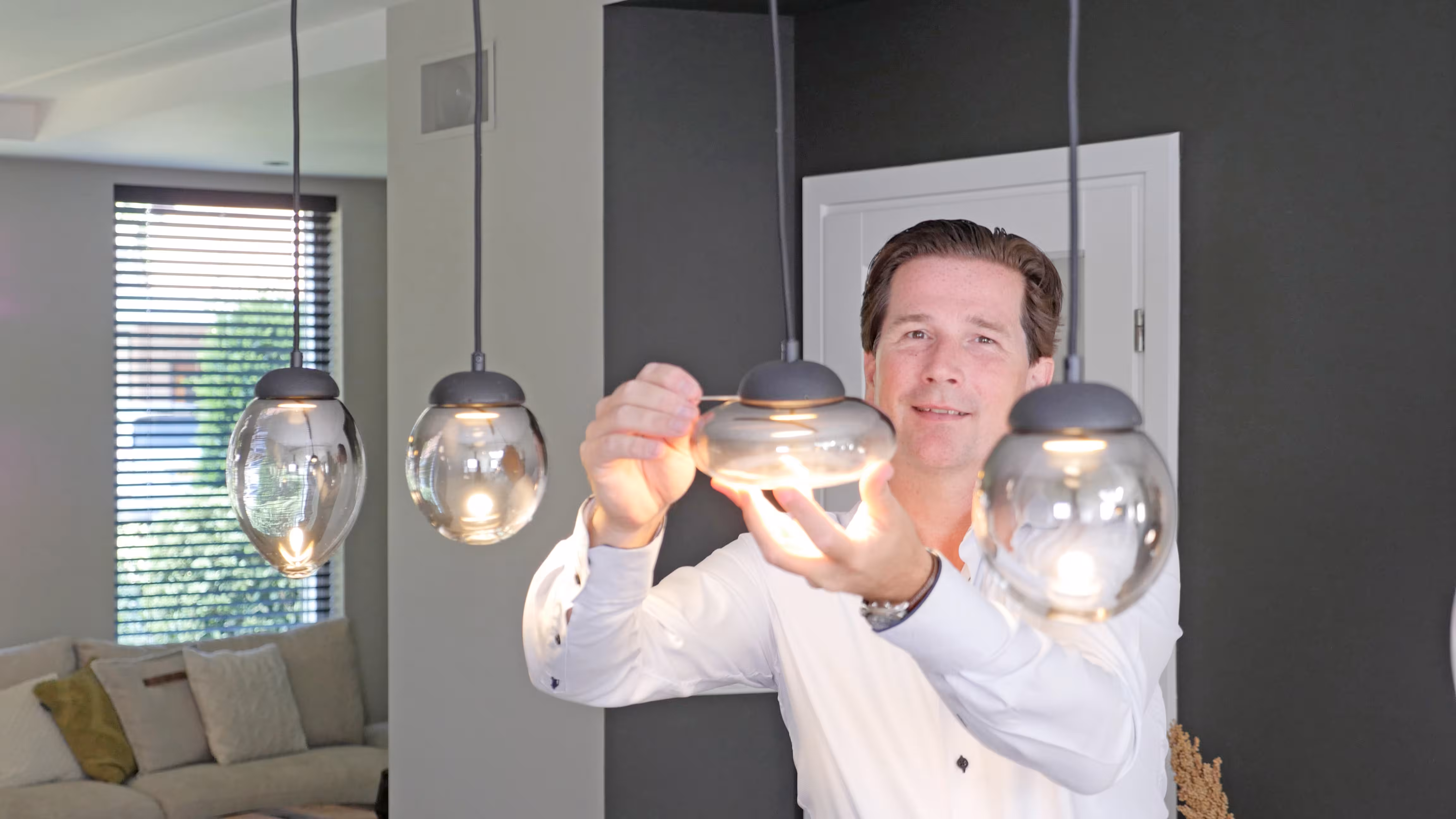 Keuken met een reeks glazen hanglampen boven de eettafel