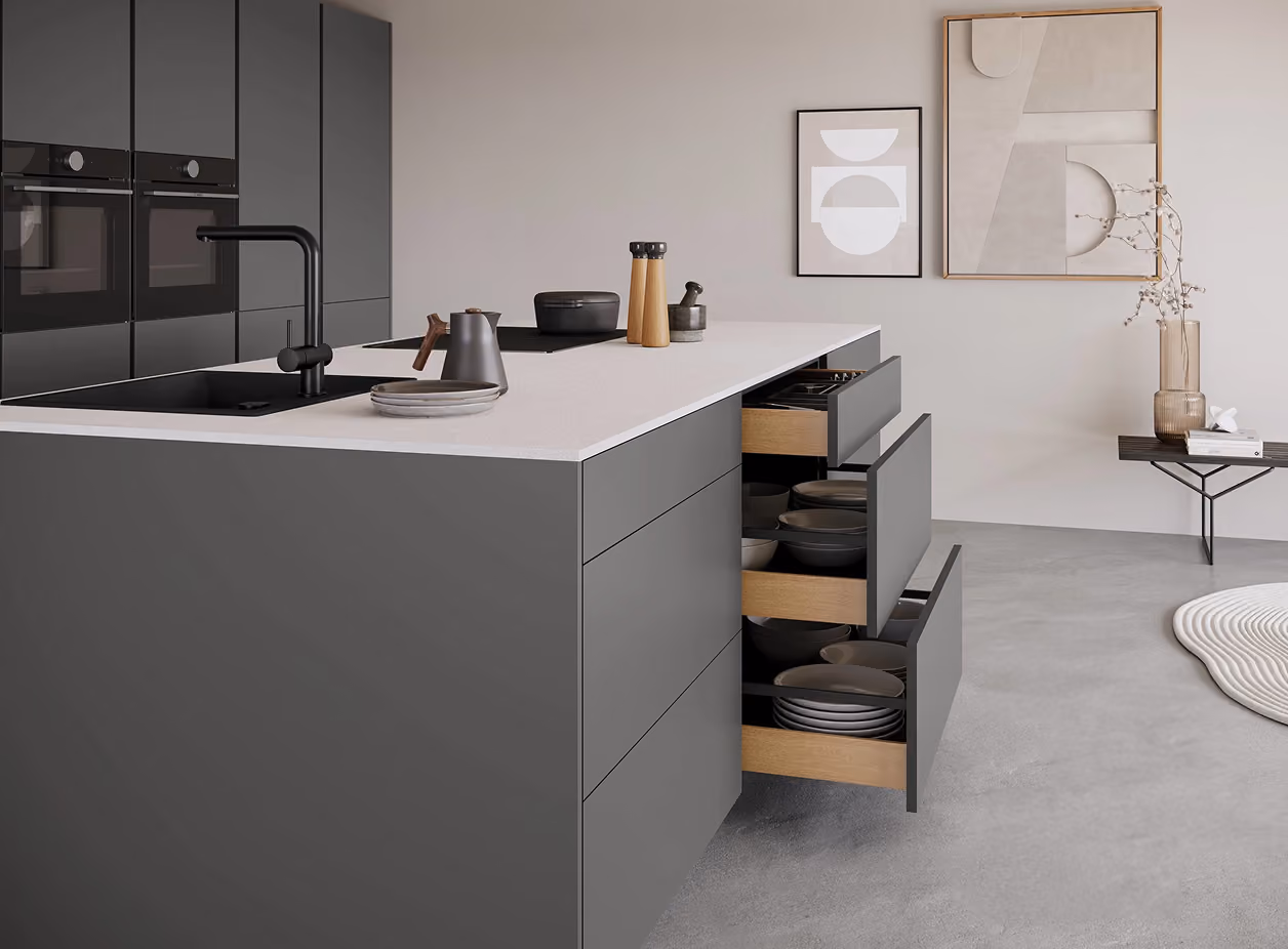 Moderne Küche in Grautönen mit weißer Arbeitsplatte, offenen Schubladen und integriertem schwarzen Wasserhahn, minimalistischer Dekoration und abstrakter Wandkunst.