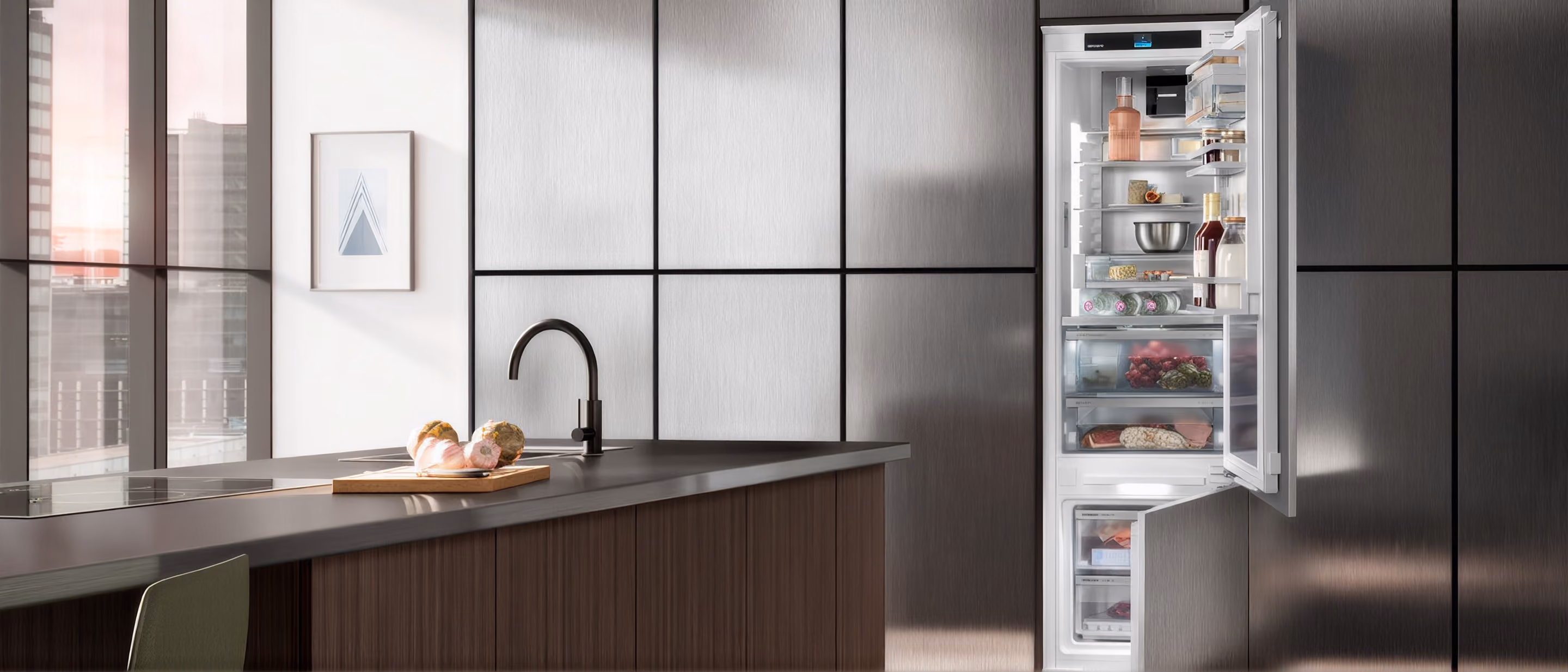 Integrierter Kühlschrank mit geöffneter Tür in einer modernen Küche mit Kochinsel.