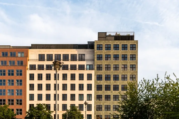 Outdoor perspective showcasing a tall building adorned with numerous windows.
