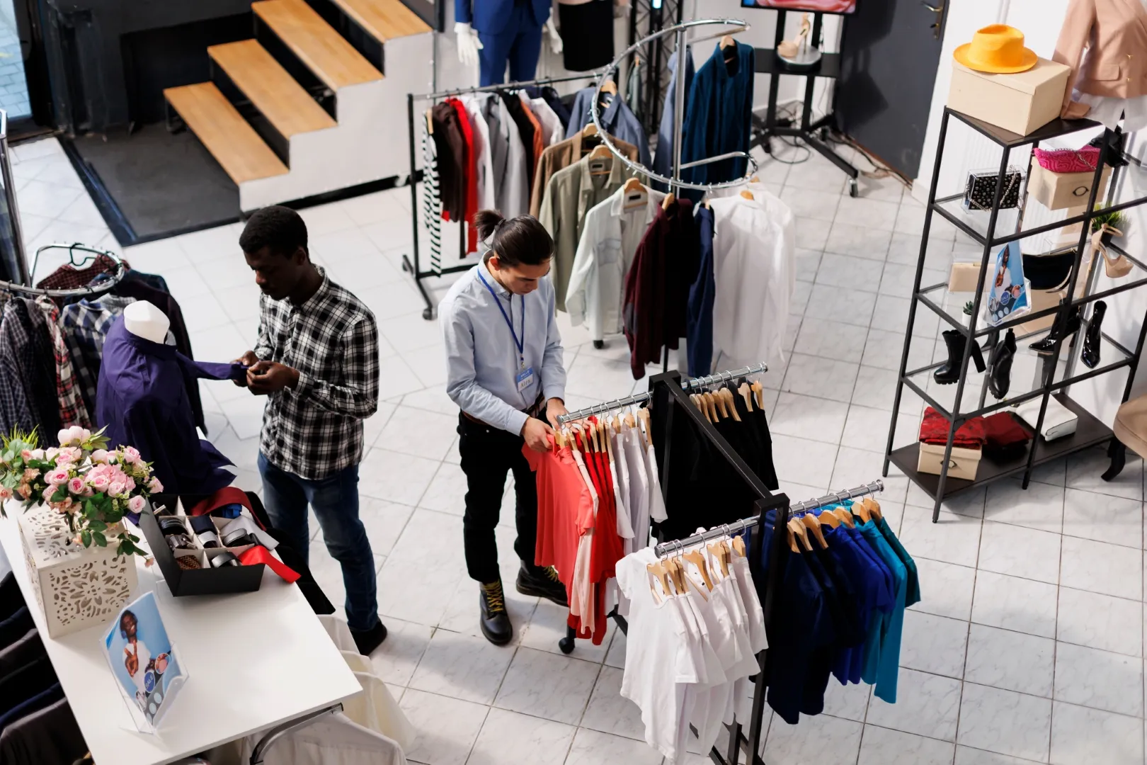 Overhead view capturing the bustling activity of a clothing retail store, with customers leisurely browsing and shopping for garments.