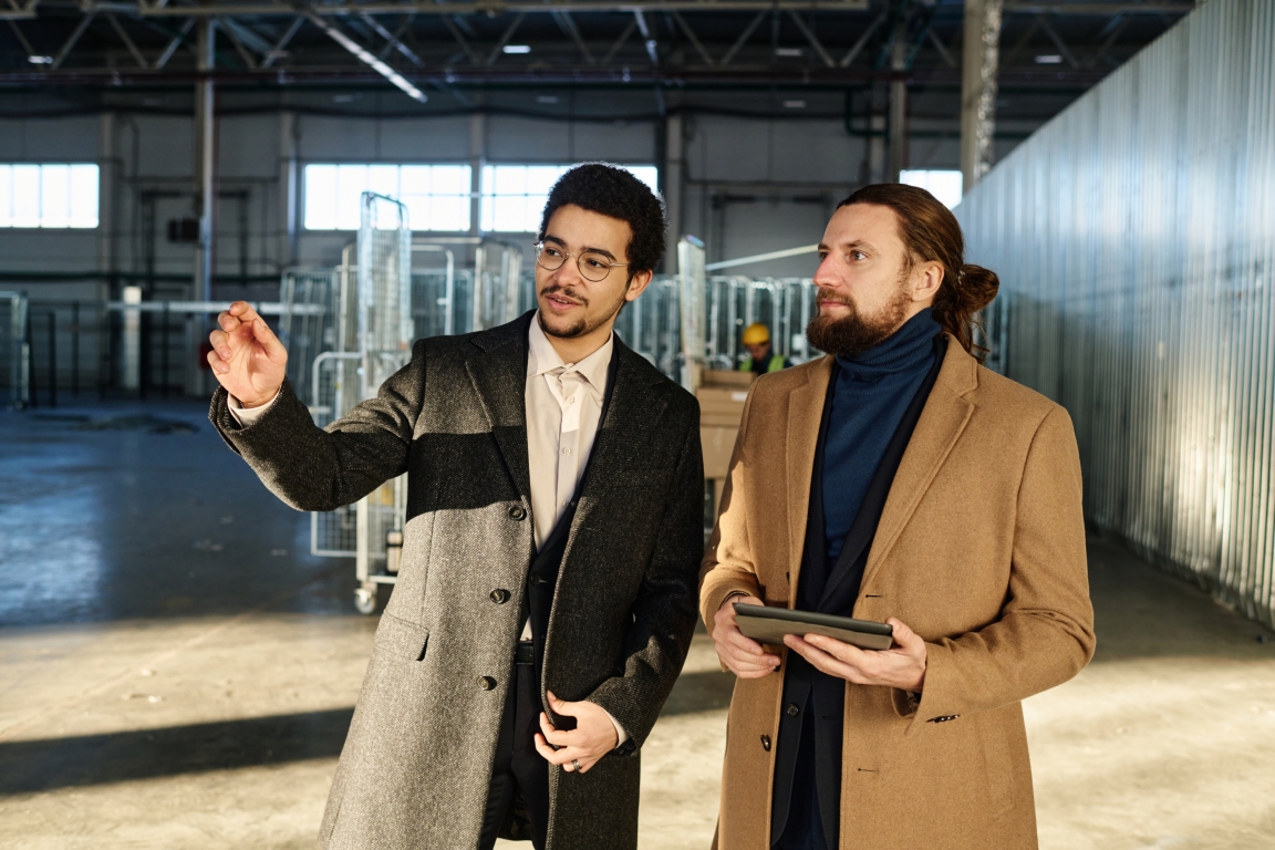 Two men in a building discussing details about it.