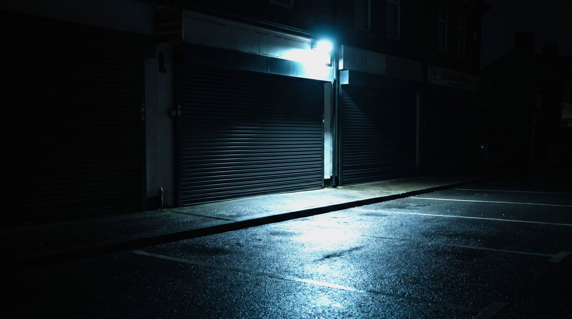 Closed storefront at night under a single exterior light