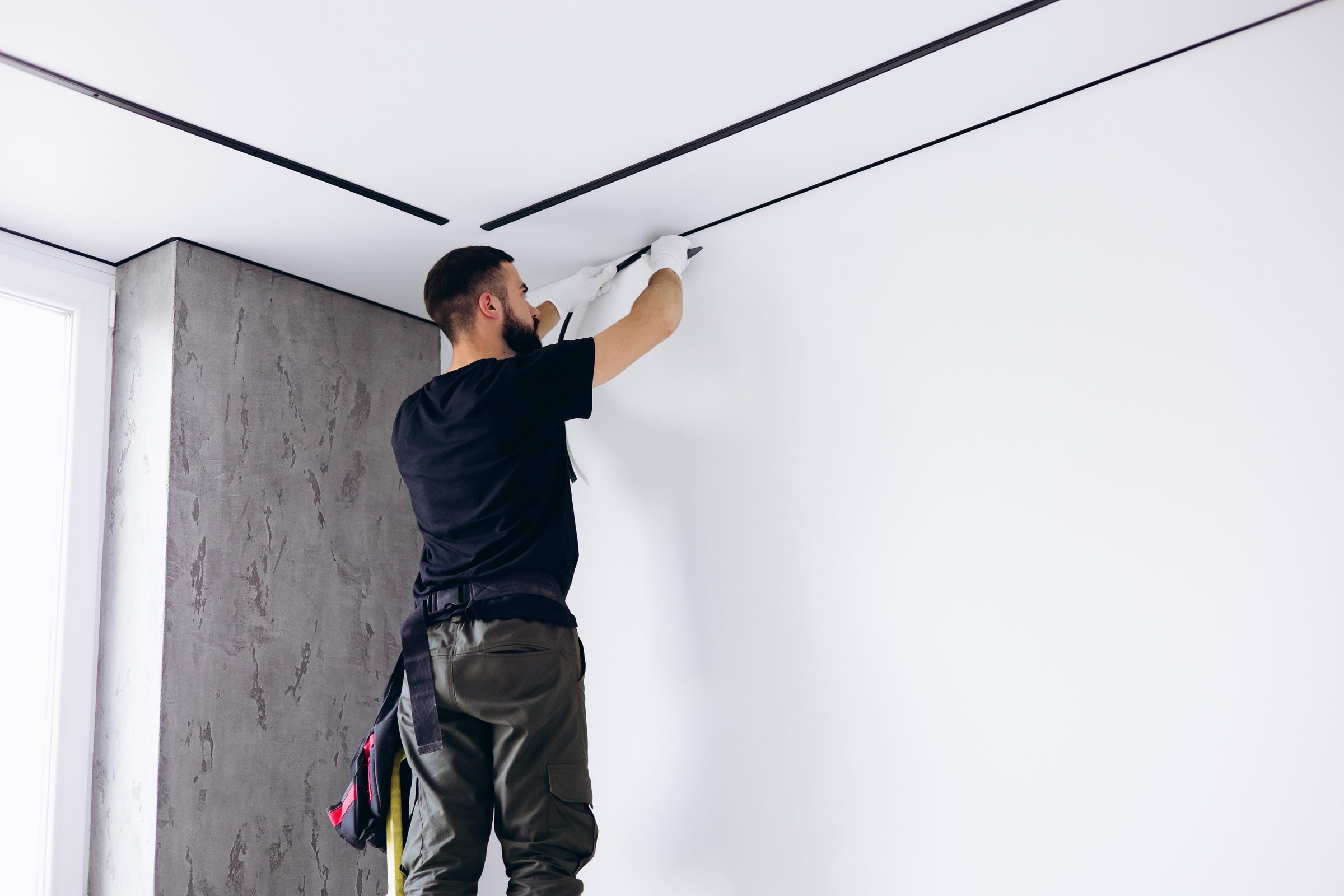 Divs meistras montuoja įtempiamas lubas