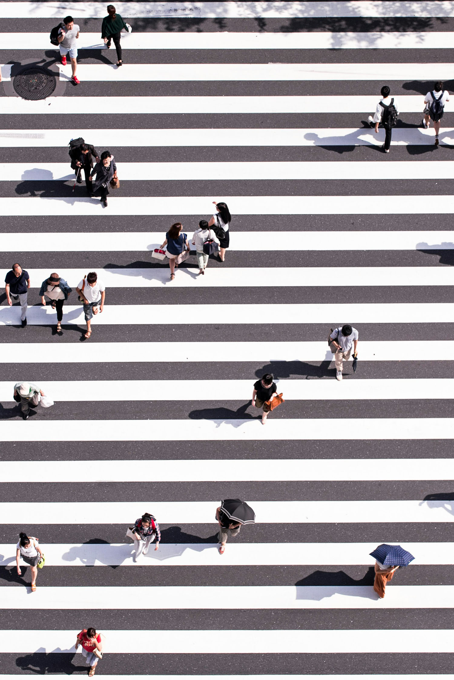Aerial view of pedestrians crossing a striped crosswalk