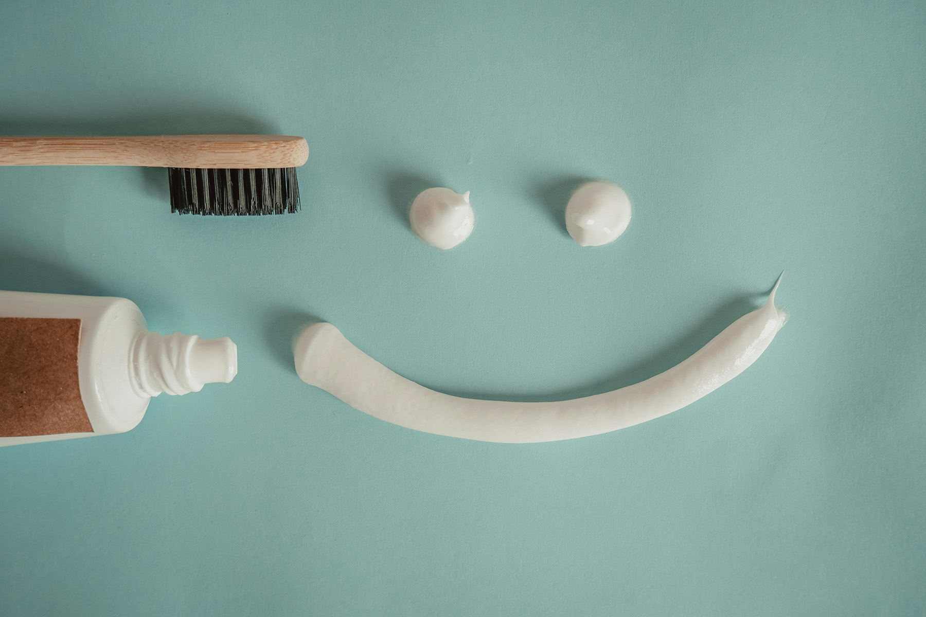 Toothbrush and toothpaste arranged in a smiley face pattern