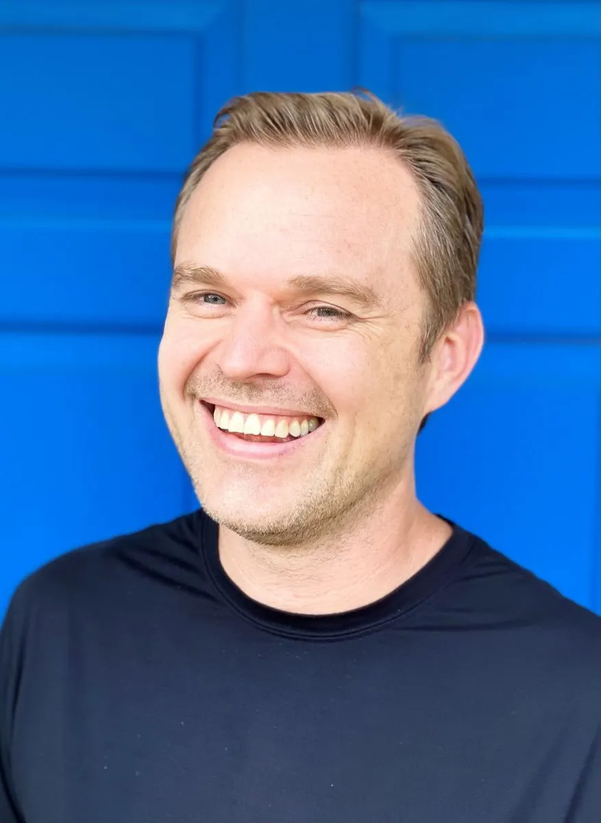 Portrait of a laughing man against a blue background