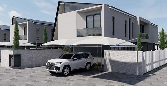 Modern two-story townhouse with a balcony and glass railing, featuring a white canopy carport where a white luxury SUV is parked on a tiled driveway, surrounded by a low brick wall and a white fence under a clear blue sky.