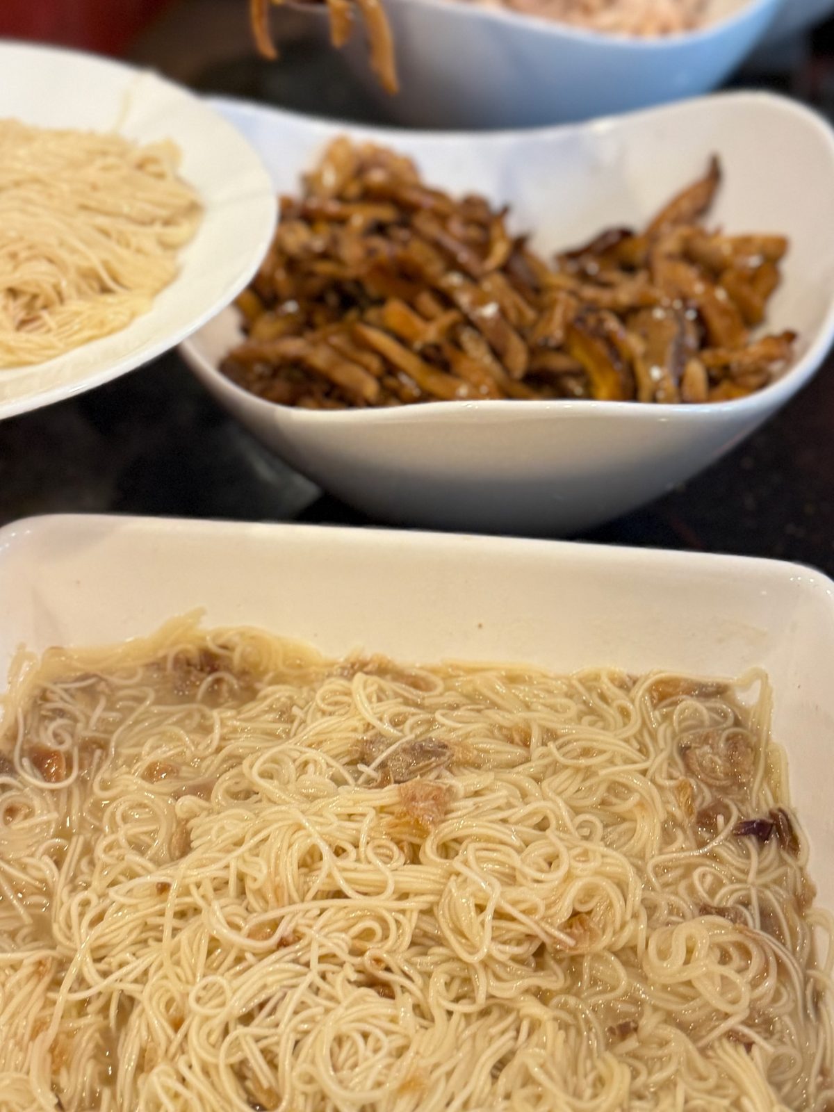 Stir-fried misua noodles in a shallow dish, loose and glossy in a little broth