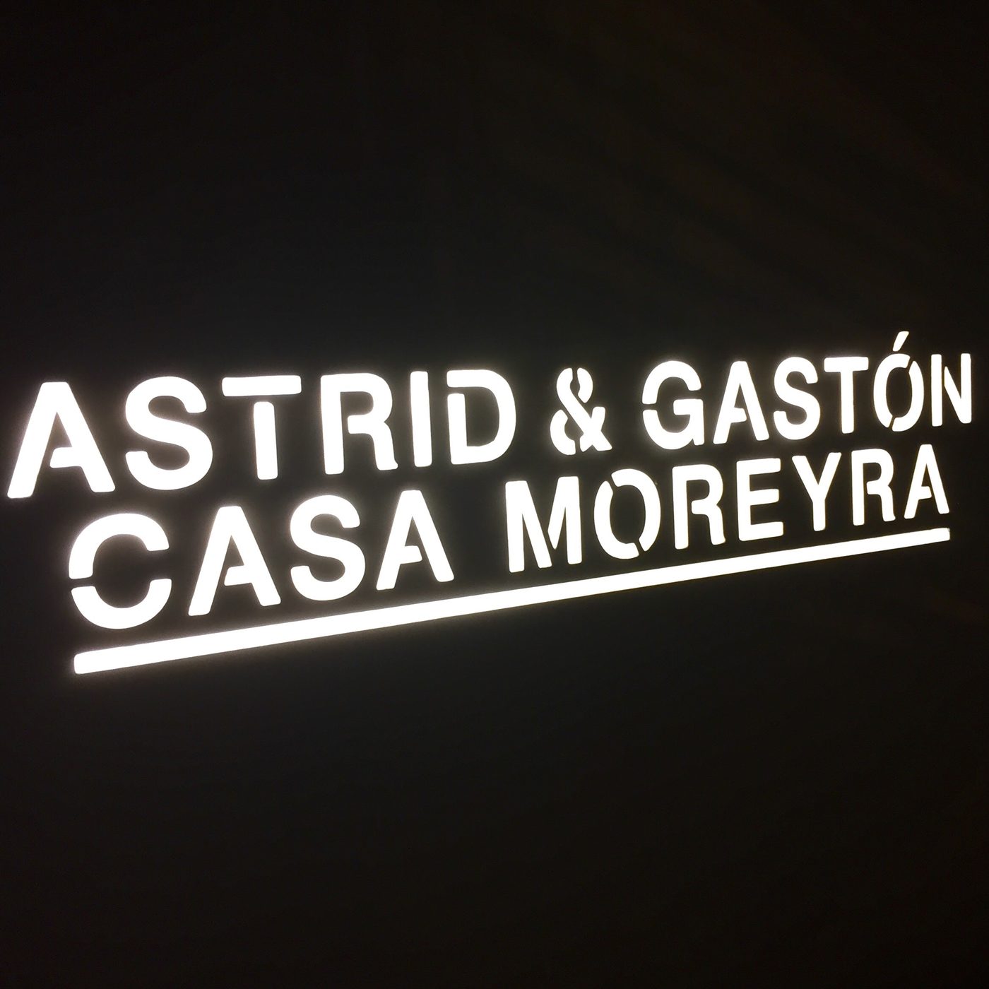 The illuminated Astrid and Gaston Casa Moreyra sign at night.