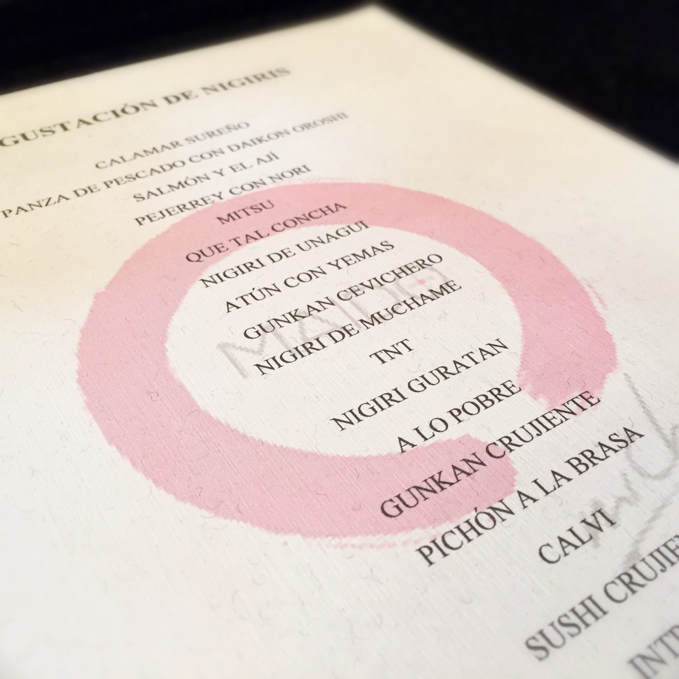 Maido's Nigiris Experience menu, twenty items printed over a thick pink open enso brushstroke.