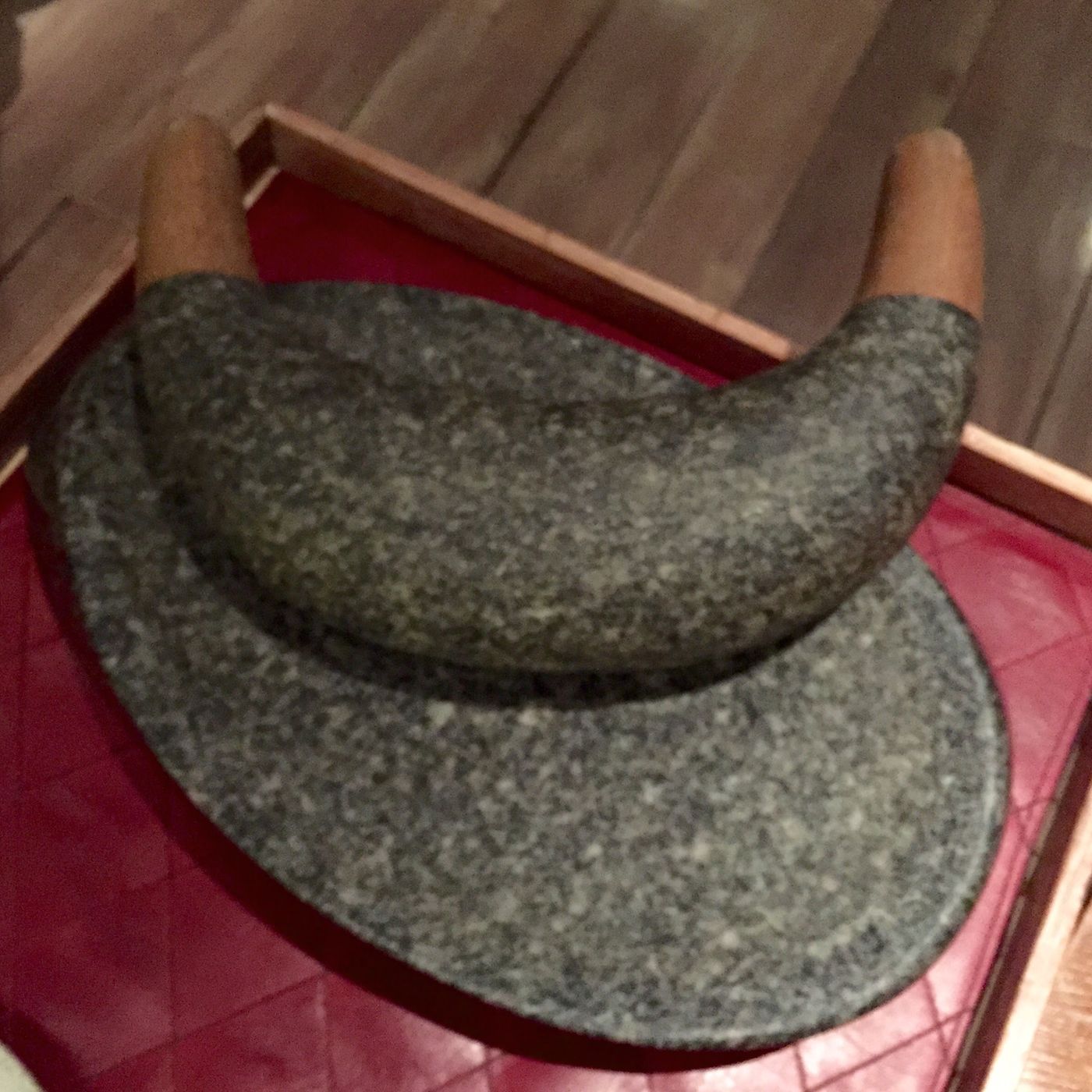 A granite batan, the Andean grinding stone with its rocking crescent, carried to the table on red cloth in a fitted wooden case.