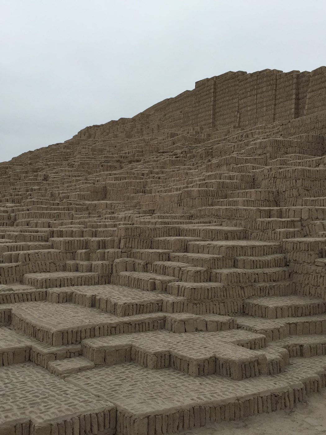 Handmade adobe bricks stood upright in tight rows, stepping back in terraces up the face of the Huaca Pucllana pyramid in Lima.