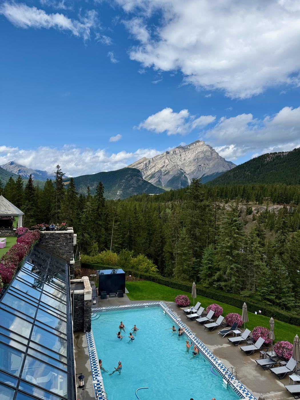 The hotel's outdoor pool seen from above, with Cascade Mountain behind it under a clear blue sky