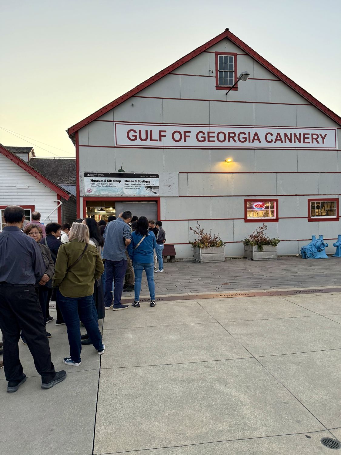 Guests lined up at dusk outside the grey and red Gulf of Georgia Cannery building in Steveston
