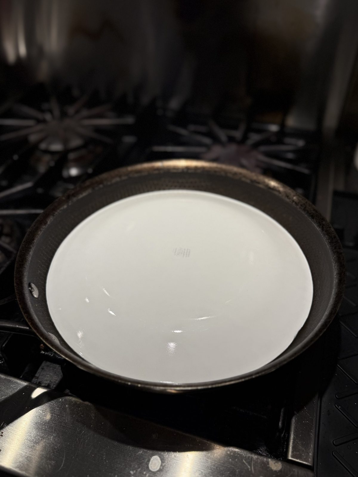 A plate placed face-down over the frying pan, ready to flip the omelette