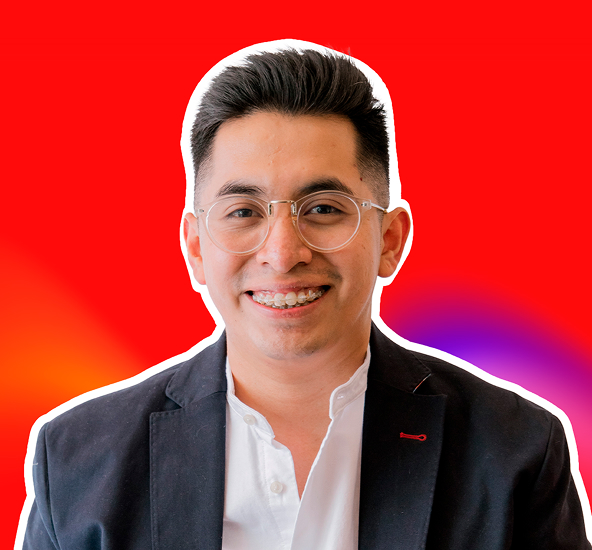 Hombre joven con gafas y brackets, vestido con chaqueta negra y camisa blanca, sonriendo frente a un fondo rojo con un contorno blanco alrededor de su figura.