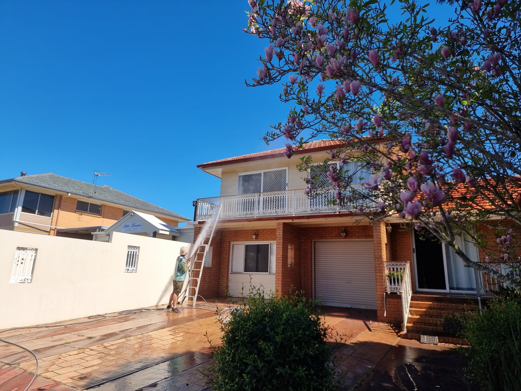 Two-storey Toowoomba home being soft washed, with the driveway and paths washed down