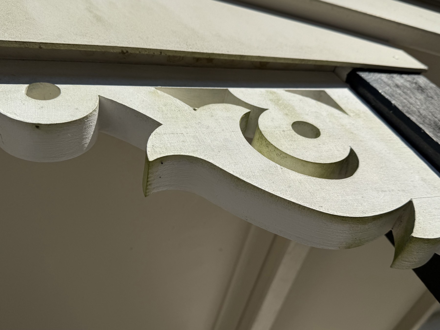Green algae growth on painted timber fretwork before soft washing