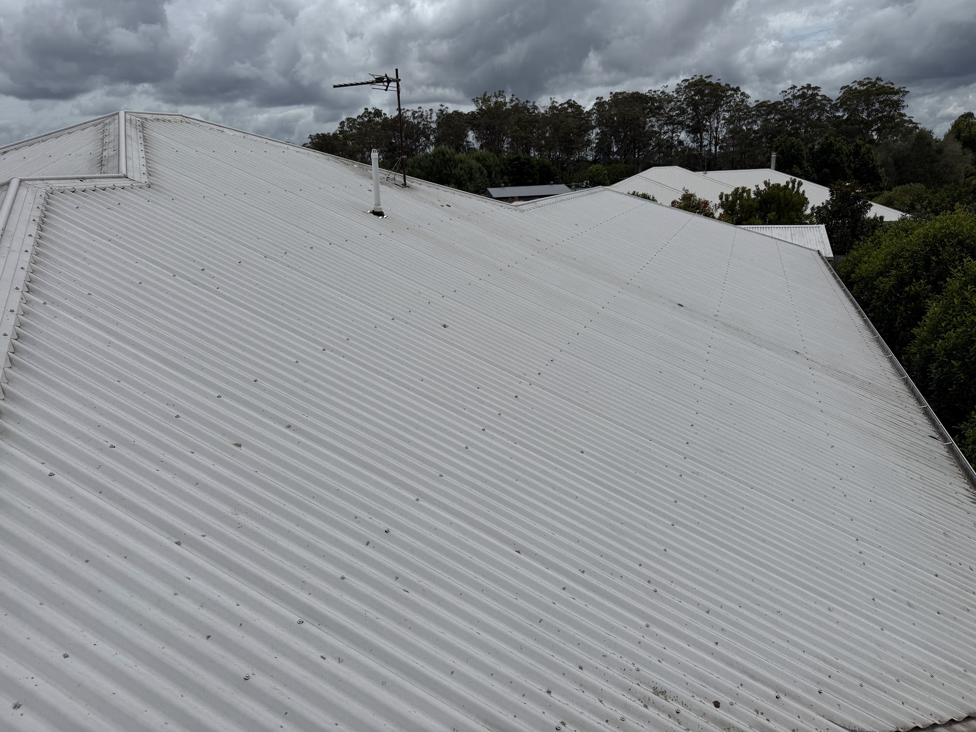 Large metal roof dulled by years of grime before a soft wash