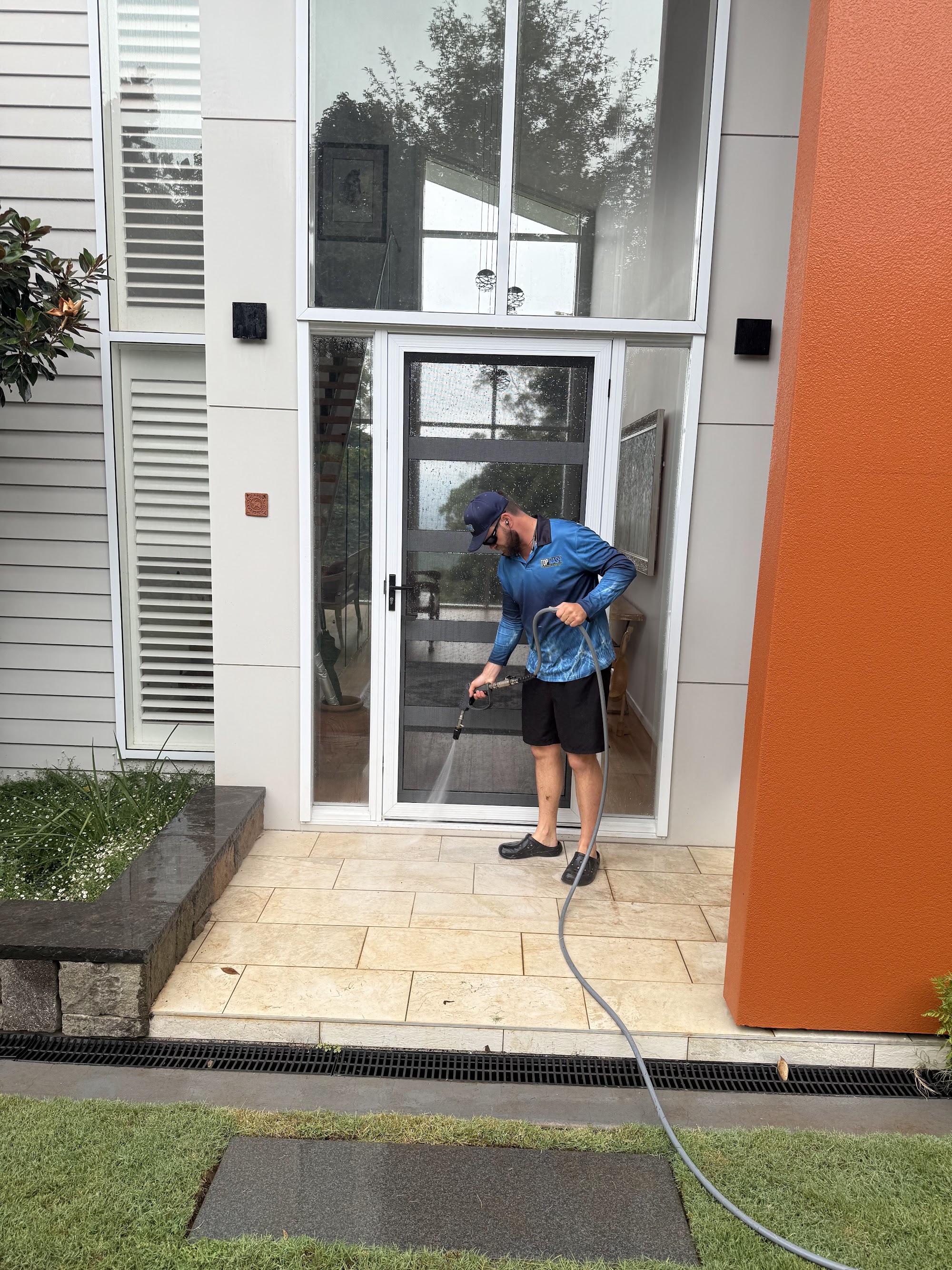 TopWash crew member washing down the tiled entry porch of a Toowoomba home
