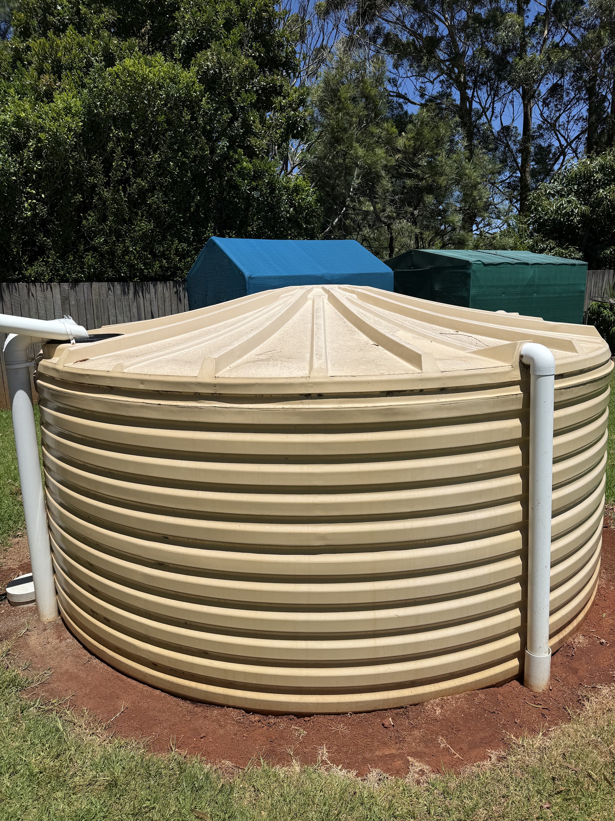 Rainwater tank showing dirt and algae streaks before its exterior clean