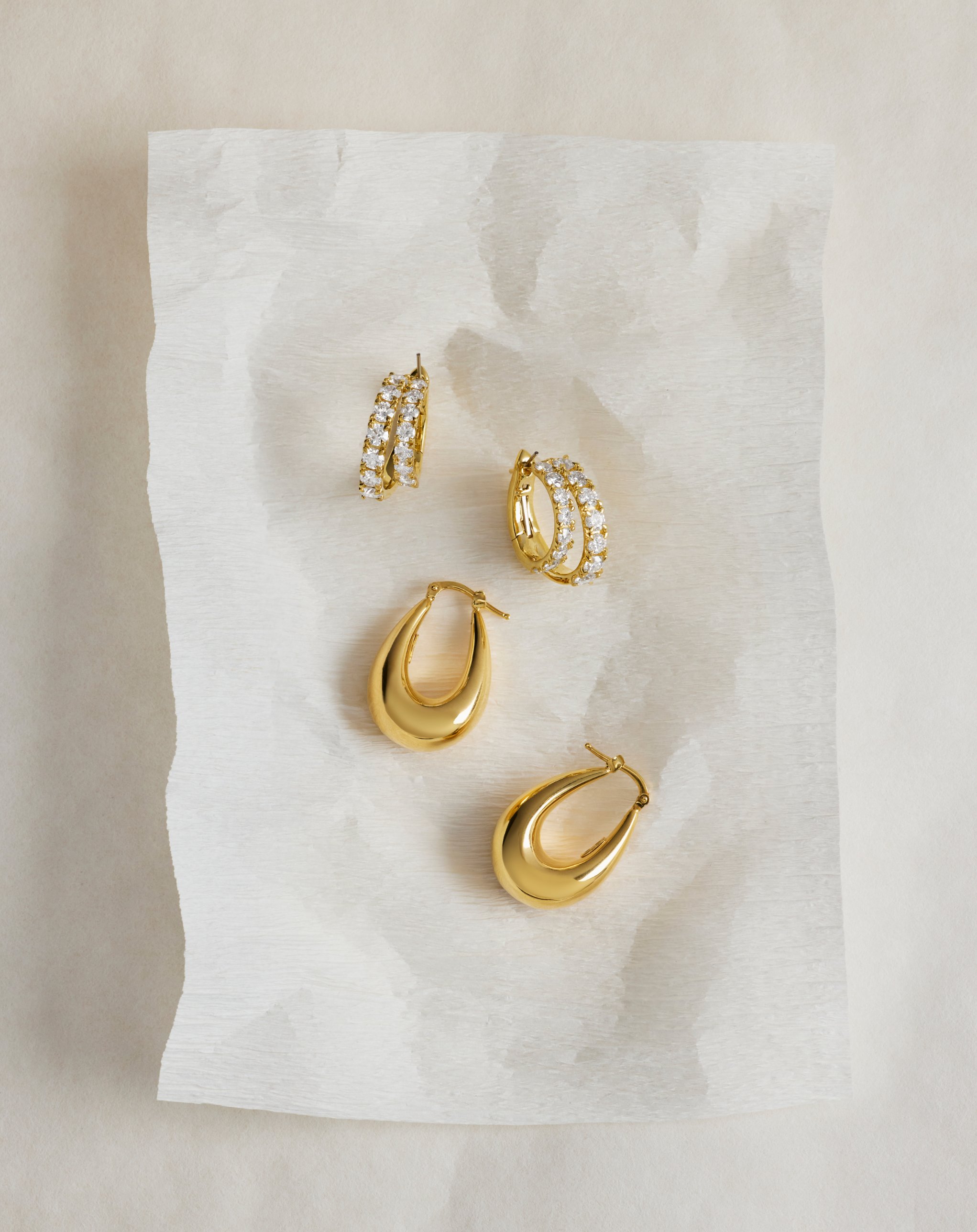 Blue Nile gold and diamond hoop earrings on textured paper