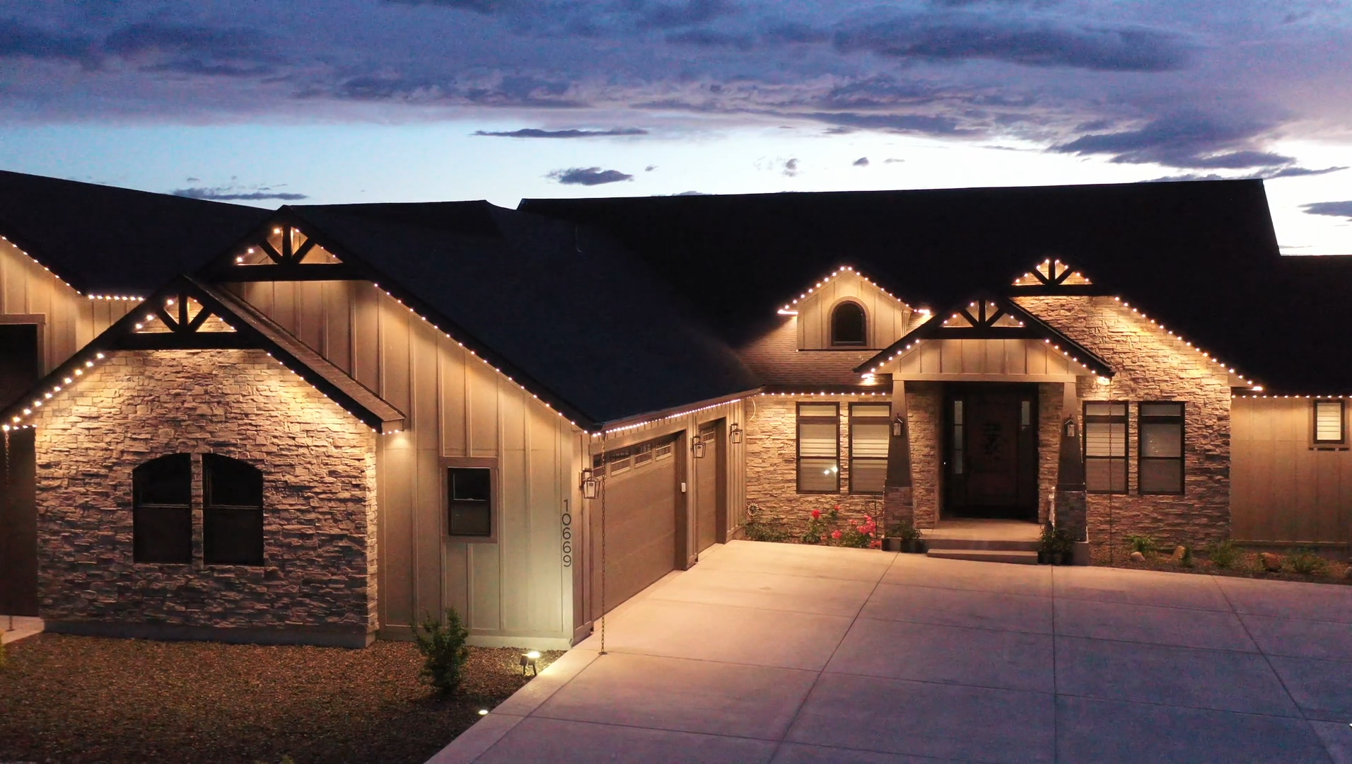 Home illuminated with warm-white permanent roofline lighting at dusk
