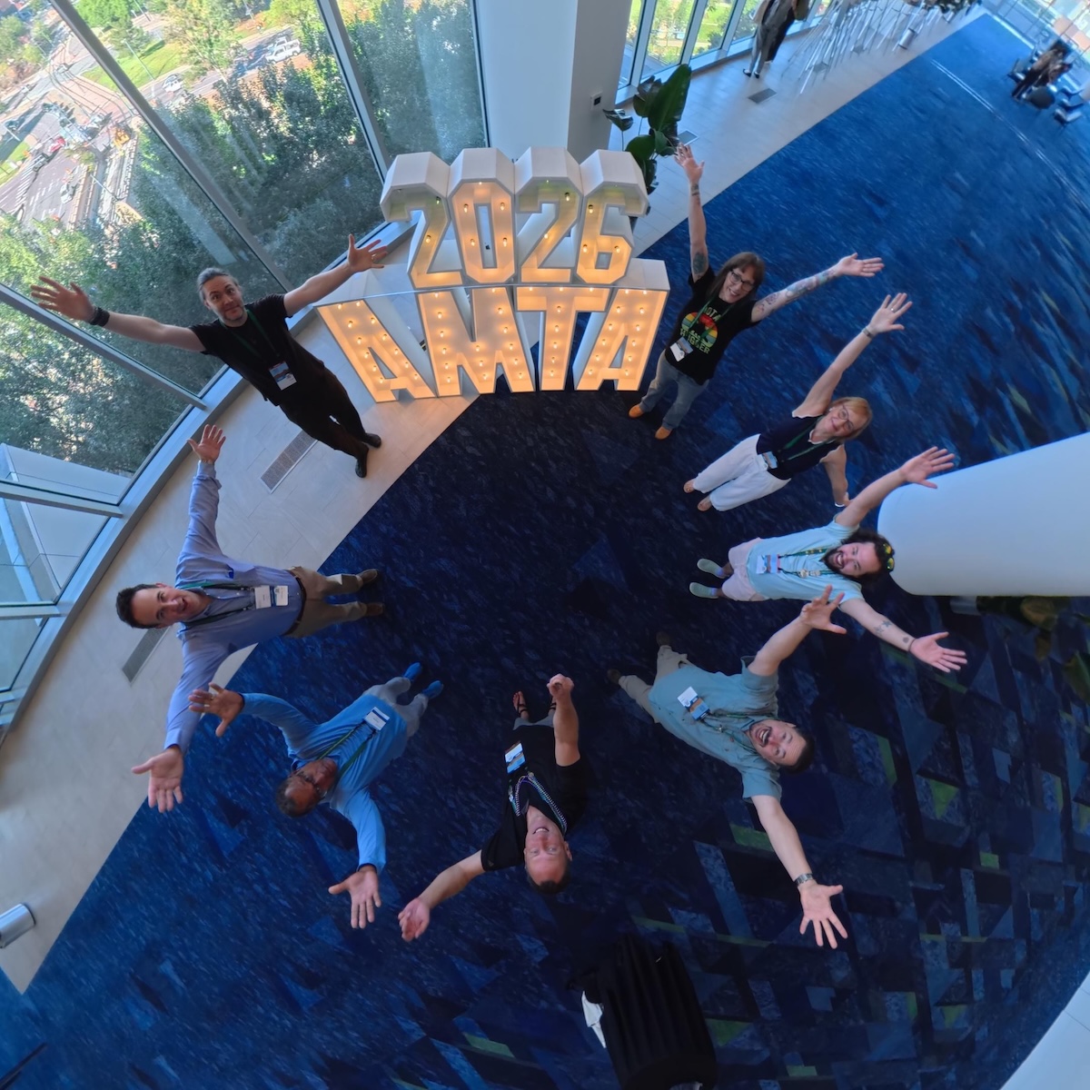 AMTA Oregon board members gathered around illuminated 2026 AMTA letters at National Convention in Denver.