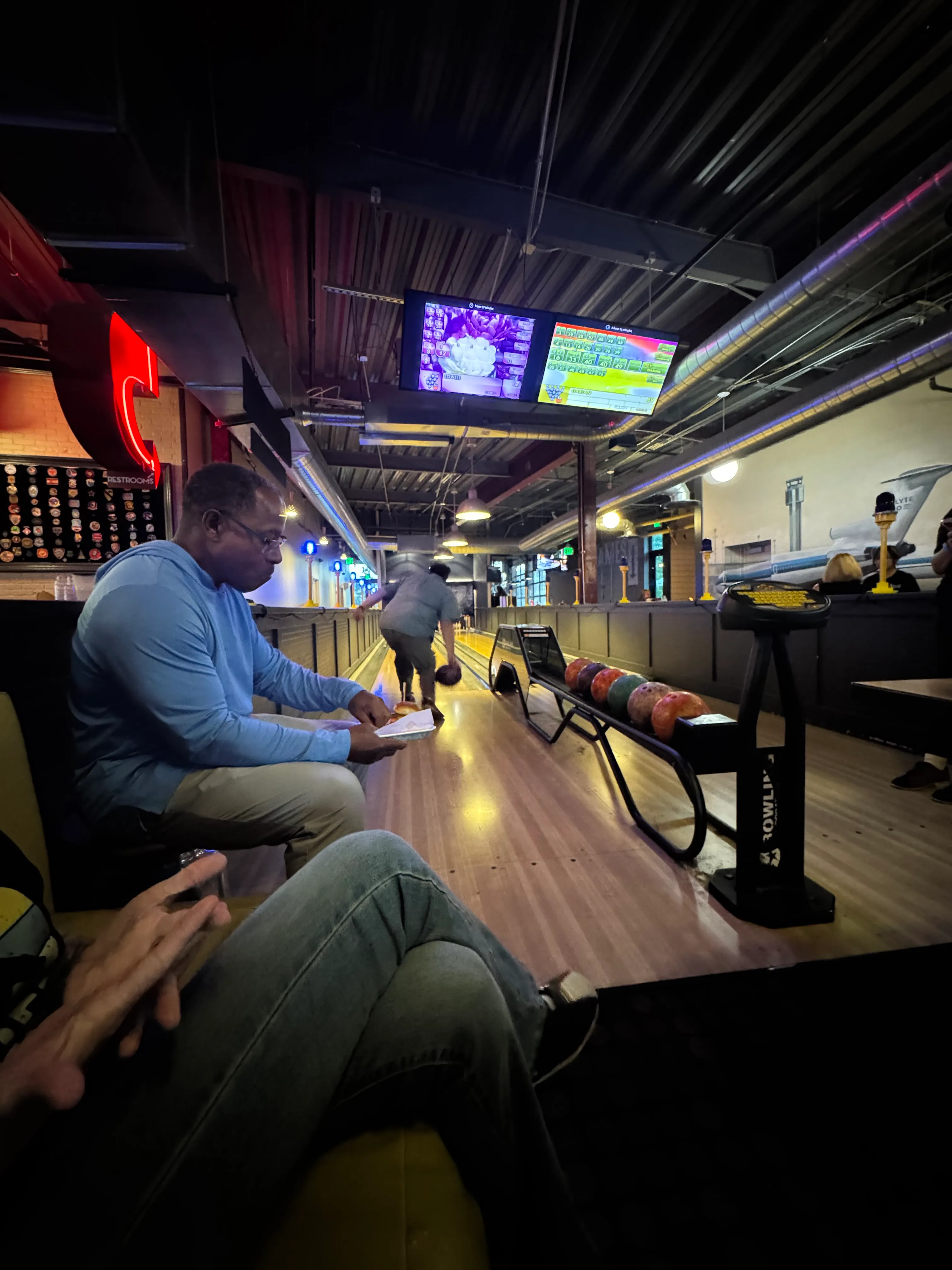 FlyteCo bowling photo 3: A member bowls while colleagues gather beside the lane in Denver.