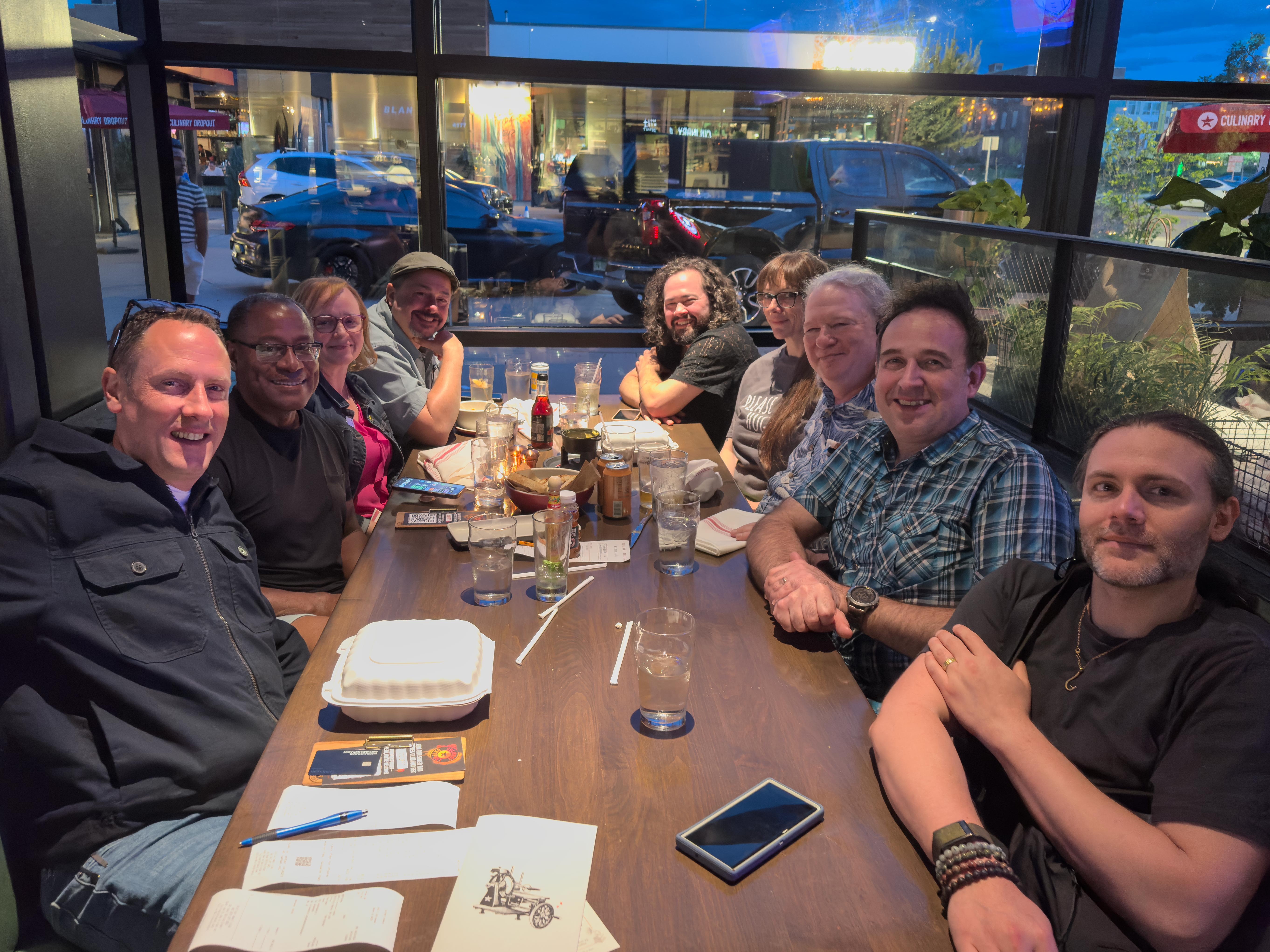 AMTA Oregon board members smiling around a restaurant table during a shared meal.