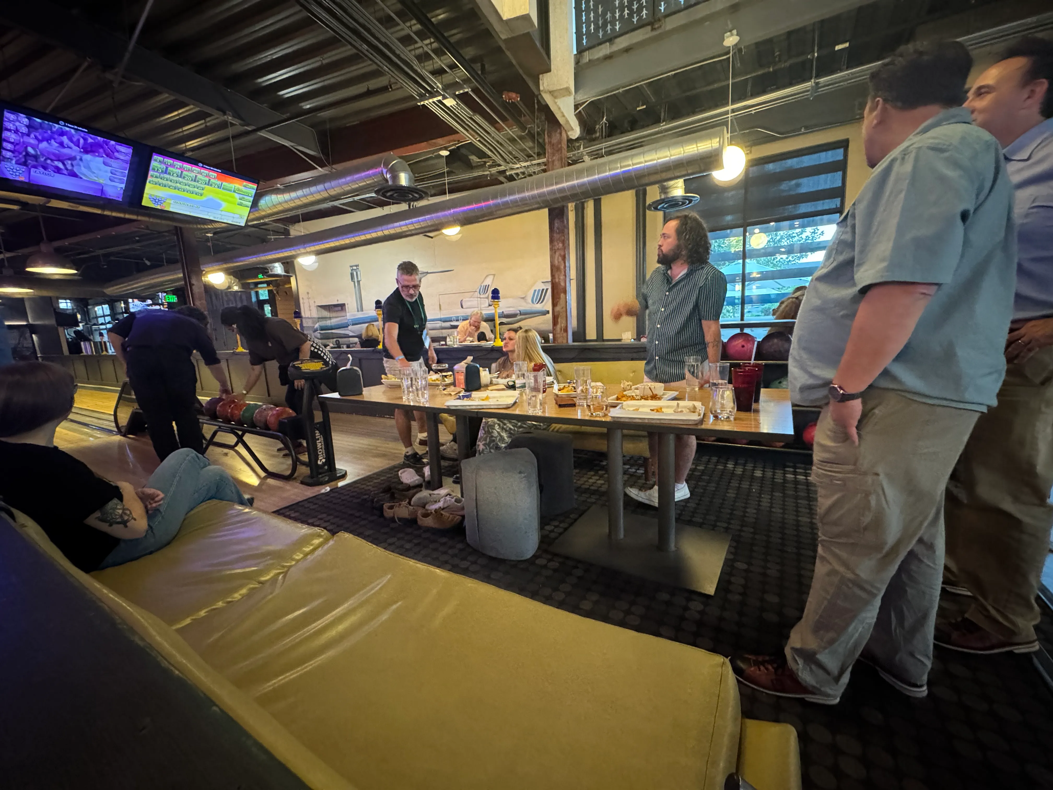 FlyteCo bowling photo 2: Oregon members gathered around a table beside the bowling lanes in Denver.