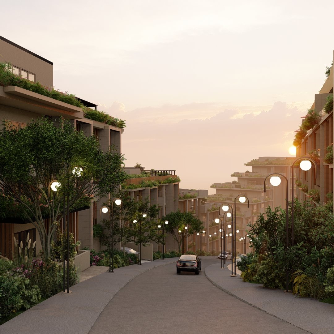 A gently curving street lined with modern multi-story buildings featuring abundant greenery on balconies and rooftops, illuminated street lamps, and a few cars driving under a soft sunset sky.