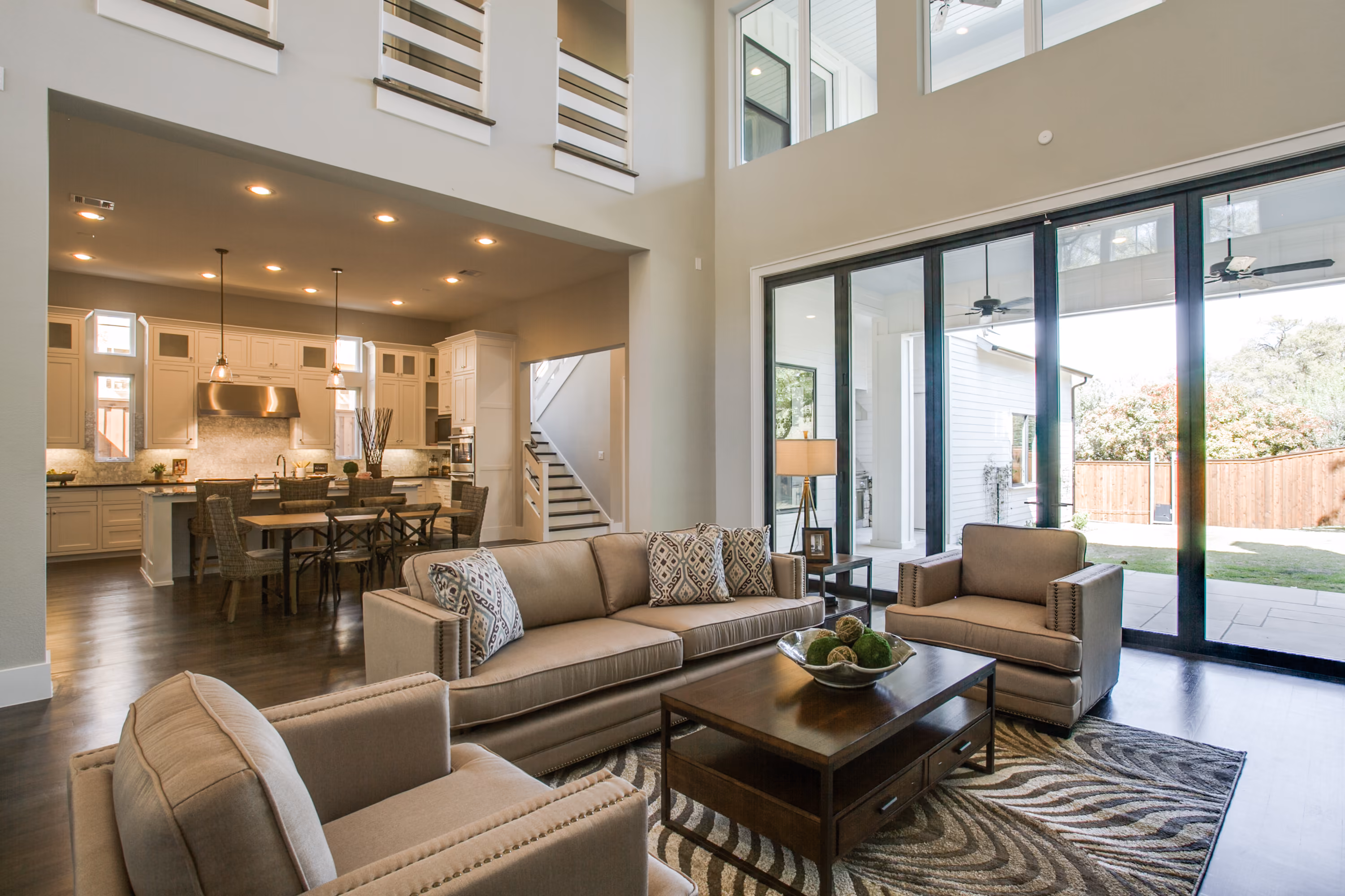 Double-height living room with a fireplace and open kitchen in a completed Cambridge home