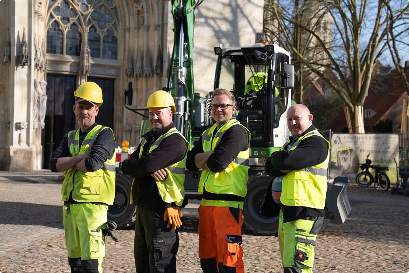 Team von Bogatzki in Warnkleidung vor einem Bagger am Münsteraner Dom