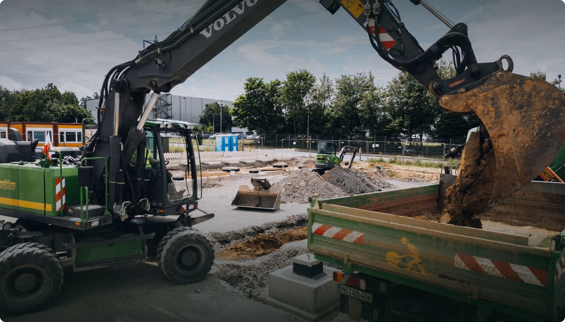 Bagger belädt einen Lkw mit Recyclingmaterial