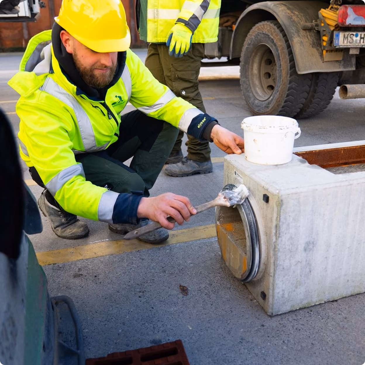 Mitarbeiter setzt einen Schacht auf der Baustelle